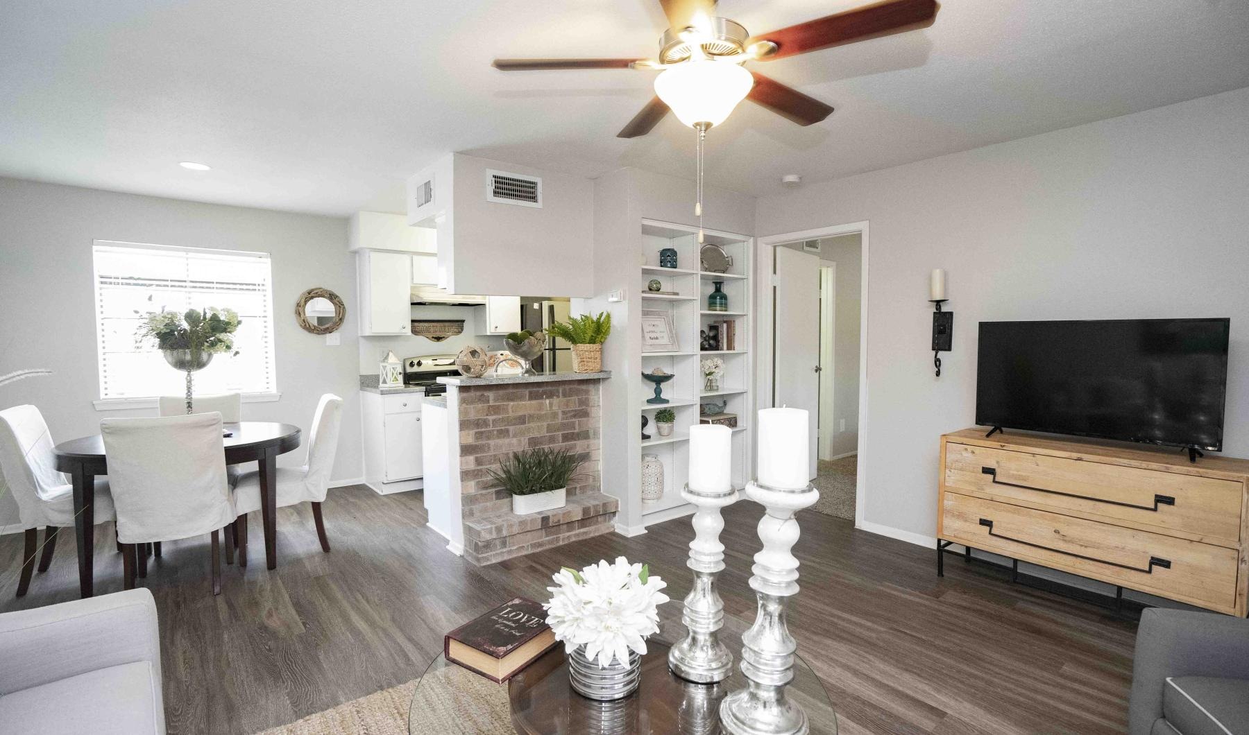 a living room with a tv, chairs and tables